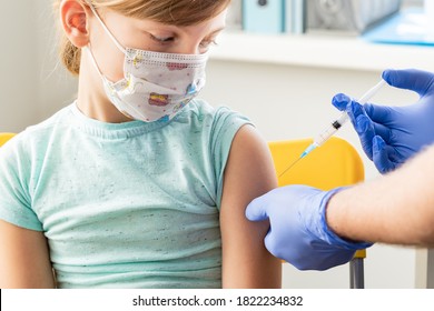 Little girl in face mask in doctor's office is vaccinated. Syringe with vaccine for covid-19 coronavirus,flu,dangerous infectious diseases. Injection after clinical trials for human, child. Medicine. - Shutterstock ID 1822234832
