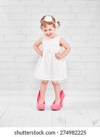 Little Girl Fashionista In Her Mother's Big Pink Heeled Shoes