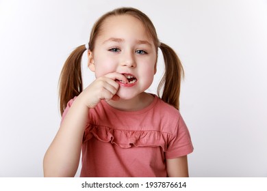 Little girl with the first swinging baby tooth