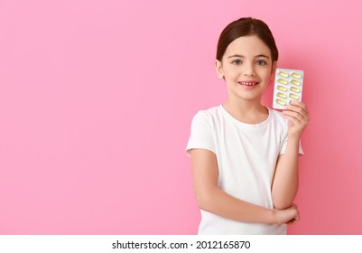 Little Girl With Fish Oil On Color Background