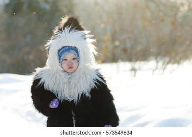 Little girl in fox fur coat in the winter park