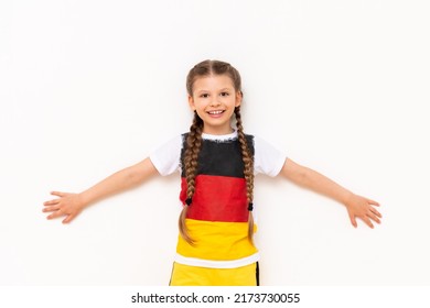 A little girl with a German flag on a T-shirt, with long hair braided in pigtails on a white isolated background. Language courses for children. Space for copying.