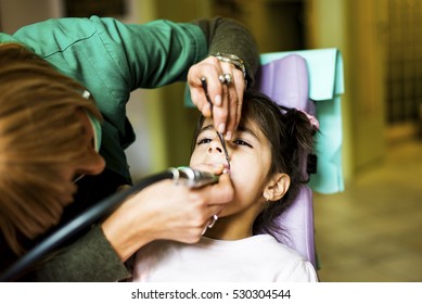 Little girl getting dental treatment in dentist office