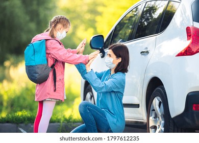 Little Girl Giving Mother High Five After School Near Car In Medical Masks