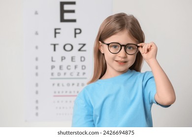 Little girl with glasses against vision test chart - Powered by Shutterstock