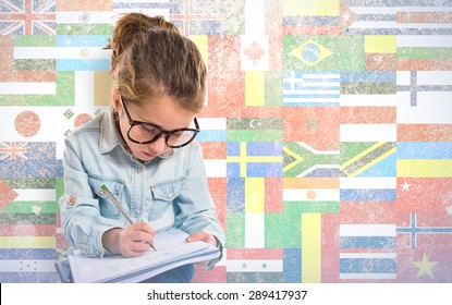 Little girl with glasses studing over flags background