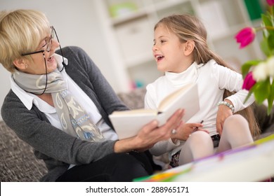 
Little Girl With Grandma Reading Interested Book