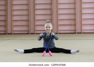 little girl gymnast with mace in the gym. The concept of an active lifestyle. Trenirvochny suit