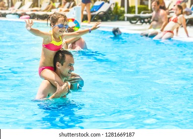 Little girl and happy dad having fun together in outdoors swimming pool - Powered by Shutterstock