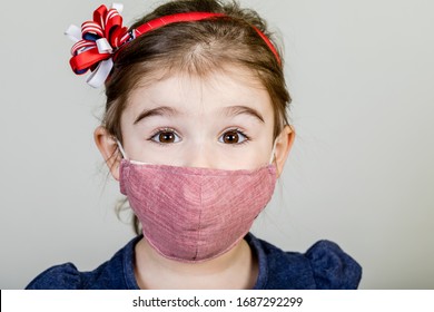 Little Girl Has Fabric Mask Protect Herself From Coronavirus COVID-19, Child With A Mask On Her Nose For Safety Outdoor Activity, Illness Or Air Pollution