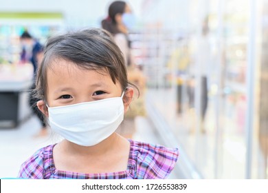 Little girl has fabric mask protect herself from Coronavirus when child go to supermarket with mother after supermarket open again ,child with a mask on nose for safety outdoor public place activity