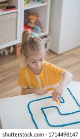 Little Girl Has A Fun Time Playing With Toy Animal Figures.Child Learning Animals. Early Education And Development.