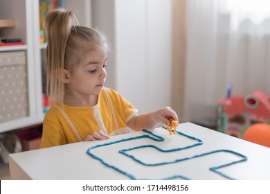 Little Girl Has A Fun Time Playing With Toy Animal Figures.Child Learning Animals. Early Education And Development.