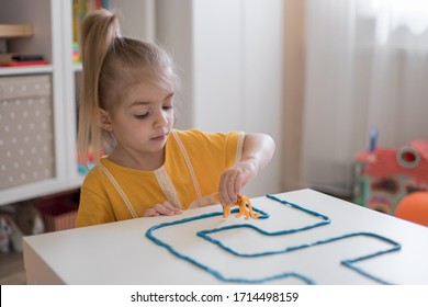 Little Girl Has A Fun Time Playing With Toy Animal Figures.Child Learning Animals. Early Education And Development.