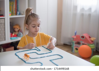 Little Girl Has A Fun Time Playing With Toy Animal Figures.Child Learning Animals. Early Education And Development.