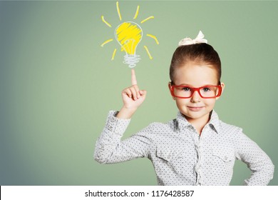 Little girl has and idea on chalkboard background - Shutterstock ID 1176428587