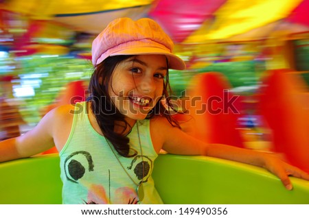 Little girl having fun in a carousel 