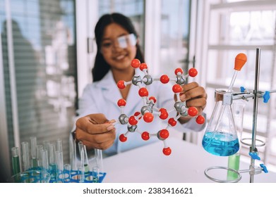 Little girl having fun holding a molecular model learning chemistry science in the classroom. science laboratory