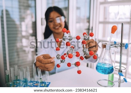 Little girl having fun holding a molecular model learning chemistry science in the classroom. science laboratory