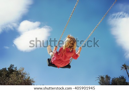 Little girl having fun on a swing outdoor