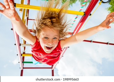 Little Girl Having Fun Playing On Monkey Bars