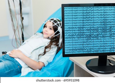 Little girl having her brain waves recorded via electroencephalograph