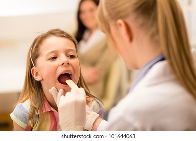 Little Girl Having Throat Examination With Tongue Depressor