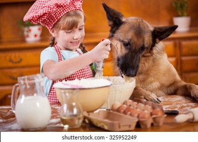 A Little Girl And Her Friend Dog Make A Mess In The Kitchen