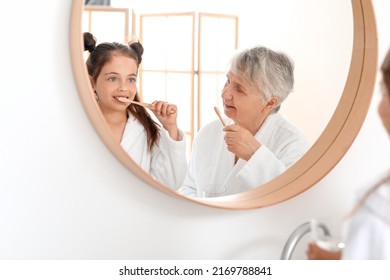 Little girl and her grandma brushing teeth in bathroom