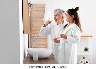 Little girl and her grandma brushing teeth in bathroom - Powered by Shutterstock