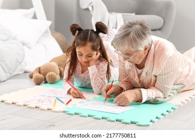 Little Girl And Her Grandma Drawing In Bedroom