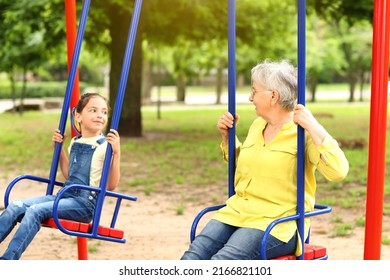 Little girl and her grandma playing on swings in park - Powered by Shutterstock