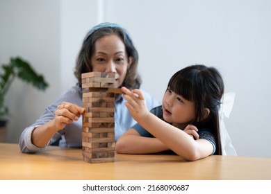 Little Girl With Her Grandma Playing Jenga Game At Home