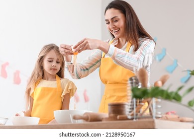 Little girl and her mother breaking eggs in kitchen on Easter day - Powered by Shutterstock