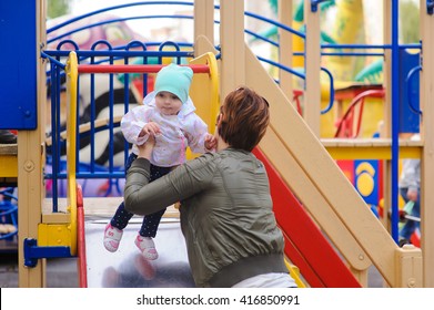 Little girl with her mother to the children's slides - Shutterstock ID 416850991