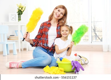 Little Girl And Her Mother With Cleaning Supplies At Home