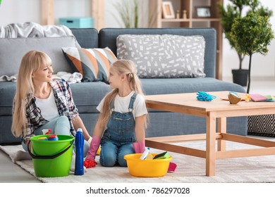 Little Girl And Her Mother With Cleaning Supplies At Home