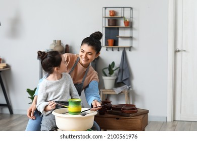 Little girl with her mother painting ceramic pot at home - Powered by Shutterstock