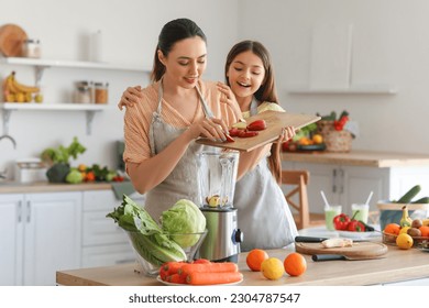 Little girl with her mother putting cut apple into blender in kitchen - Powered by Shutterstock