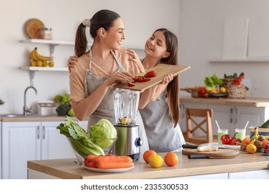 Little girl with her mother putting cut apple into blender in kitchen - Powered by Shutterstock