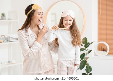 Little girl and her mother with sleeping masks brushing teeth in bathroom - Shutterstock ID 2144695601