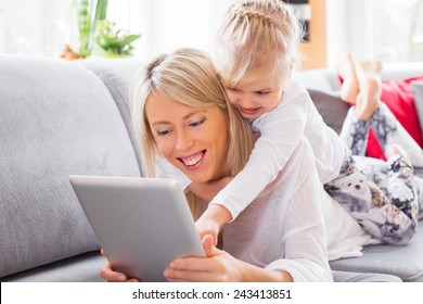 Little girl with her mother using tablet computer - Powered by Shutterstock