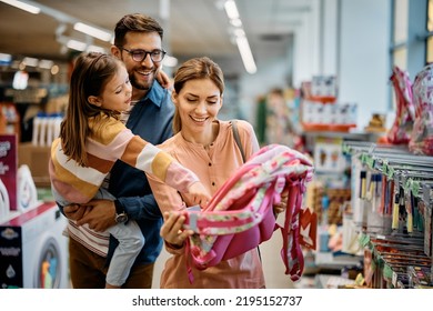 Little girl and her parents choosing backpack for school while shopping in the store together. - Shutterstock ID 2195152737