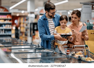 Little girl and her parents choosing groceries while shopping at supermarket. Copy space. - Powered by Shutterstock