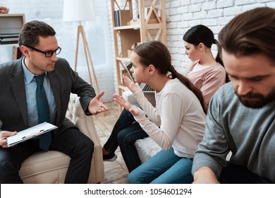 Little girl with her parents makes helpless gesture at psychologist's reception. Concept of alienation of parents. Family at reception with family psychologist. - Shutterstock ID 1054601294