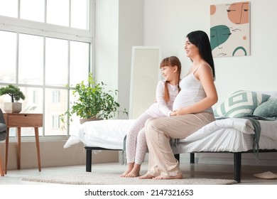 Little girl with her pregnant mother at home in morning - Powered by Shutterstock