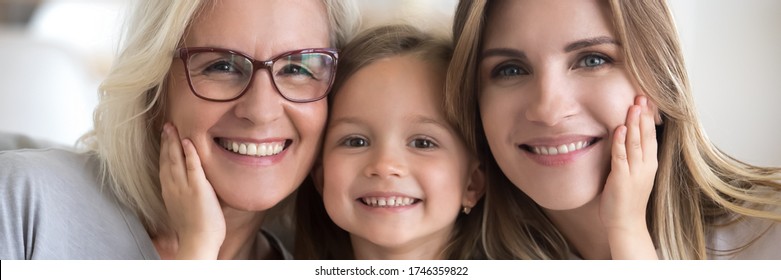 Little Girl Her Young Mother And Mature Grandma Portrait. Multi Generational Women Faces Smiling Looking At Camera Close Up View Photo, Family Bond Concept. Horizontal Banner For Website Header Design