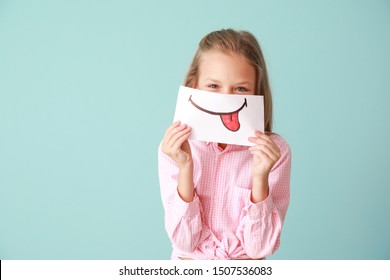 Little Girl Hiding Mouth Behind Drawn Smile On Color Background