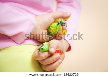 little girl hiding some candies in her hands