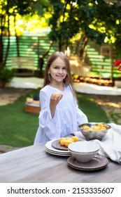 Little Girl Hold With Apricots And Cooking Breakfast In Garden Summer. Happy Child With Fruit In A Colander On A Wooden Table In Backyard. Kid Enjoy Summer Picnic, Cute Girl In Lunch Outside 
